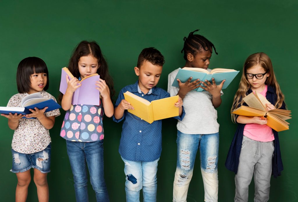 Diverse kids line up to read books in celebration of Read Across America to improve US literacy rates.