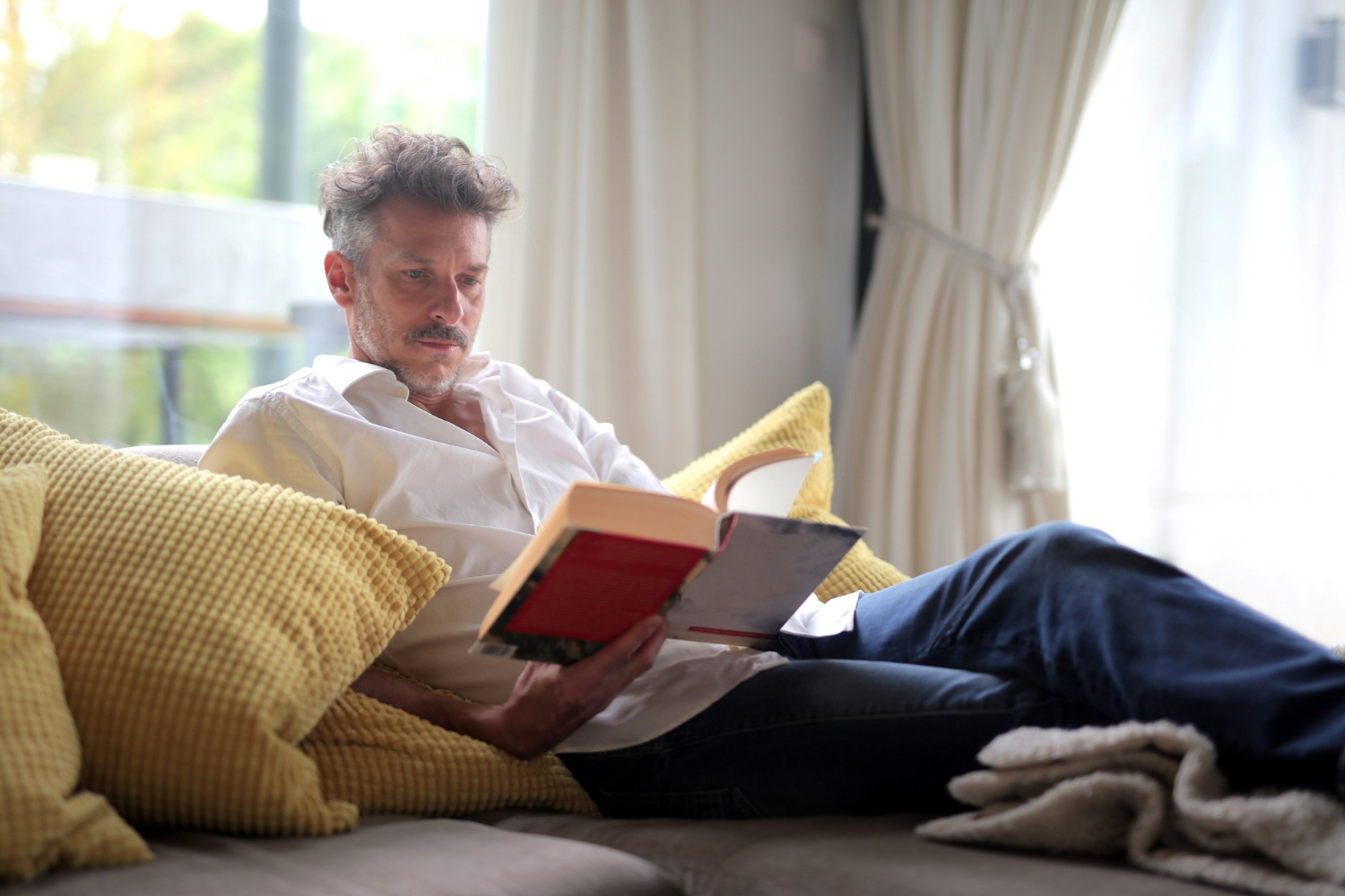 Man reading a book from the list of best books for teachers