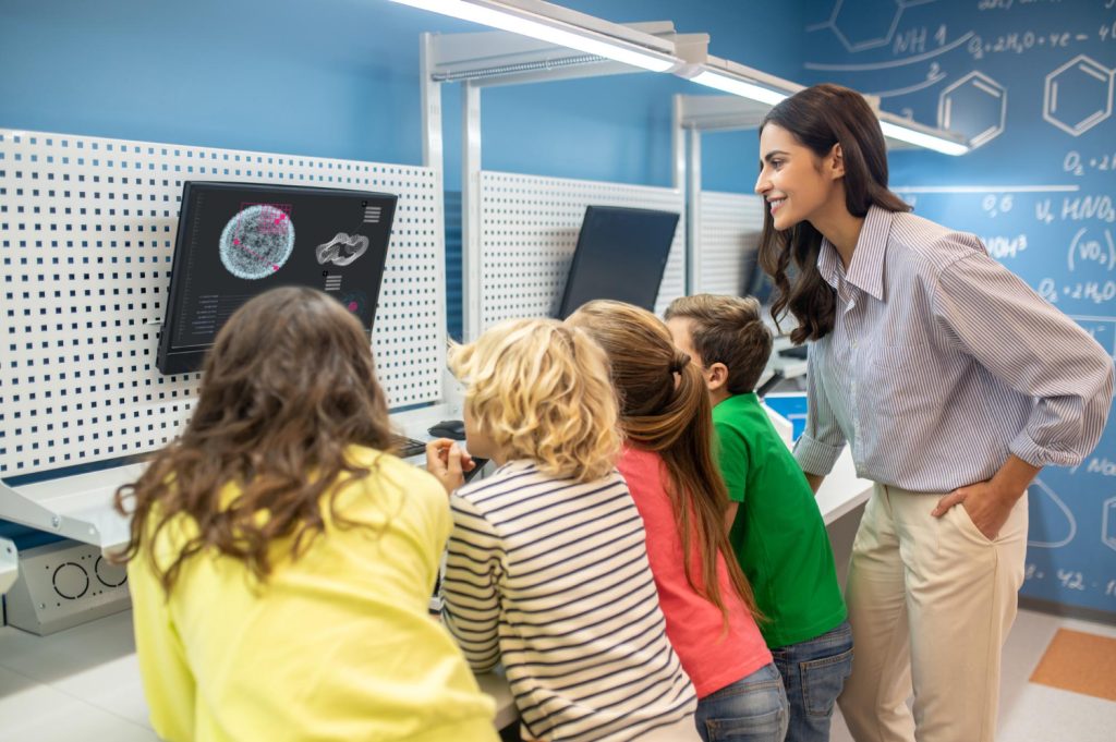 Female teacher showing students something on screen, relying on technology such as AI in education